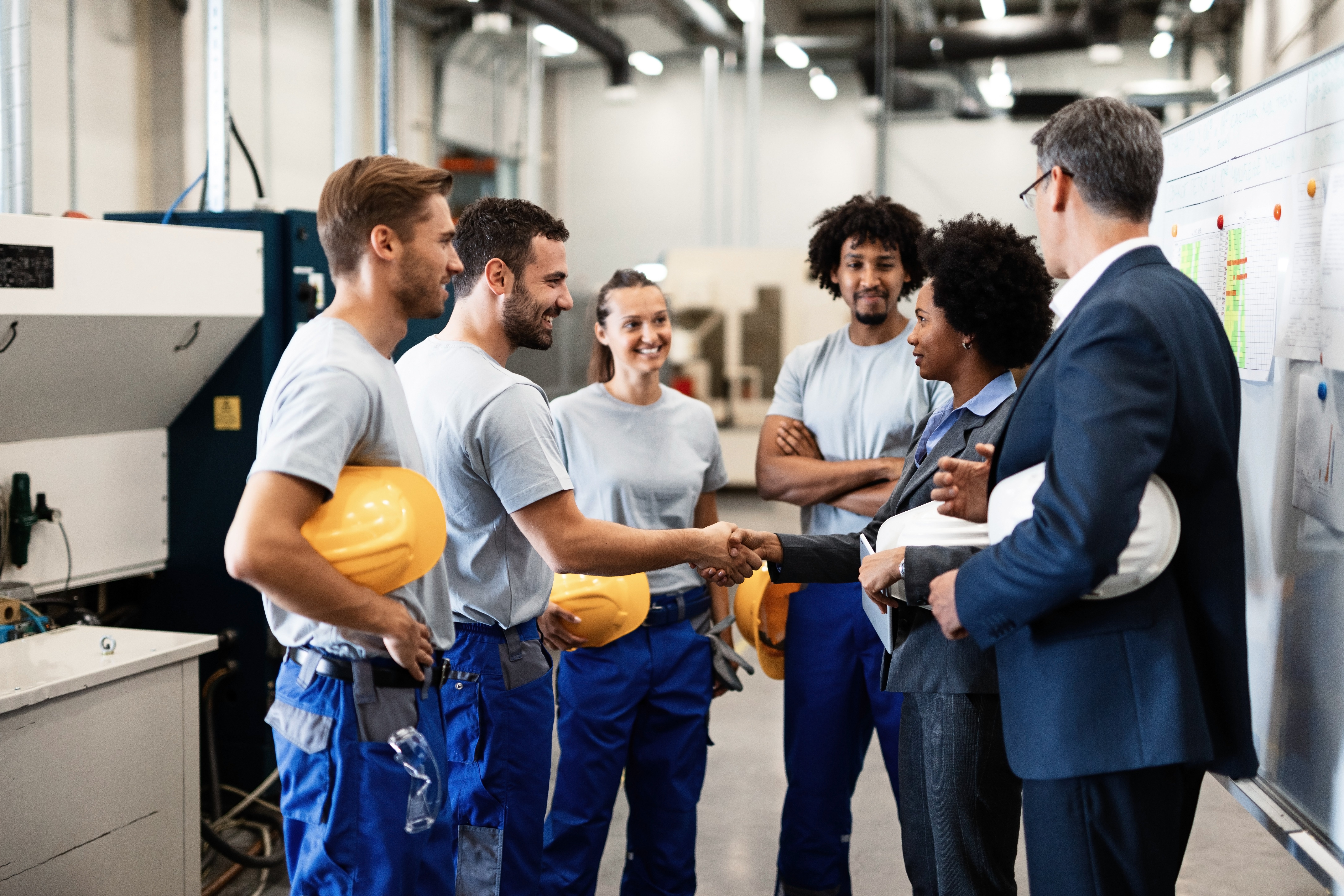 company-managers-visiting-their-employees-factory-happy-african-american-businesswoman-is-shaking-hands-with-one-worker