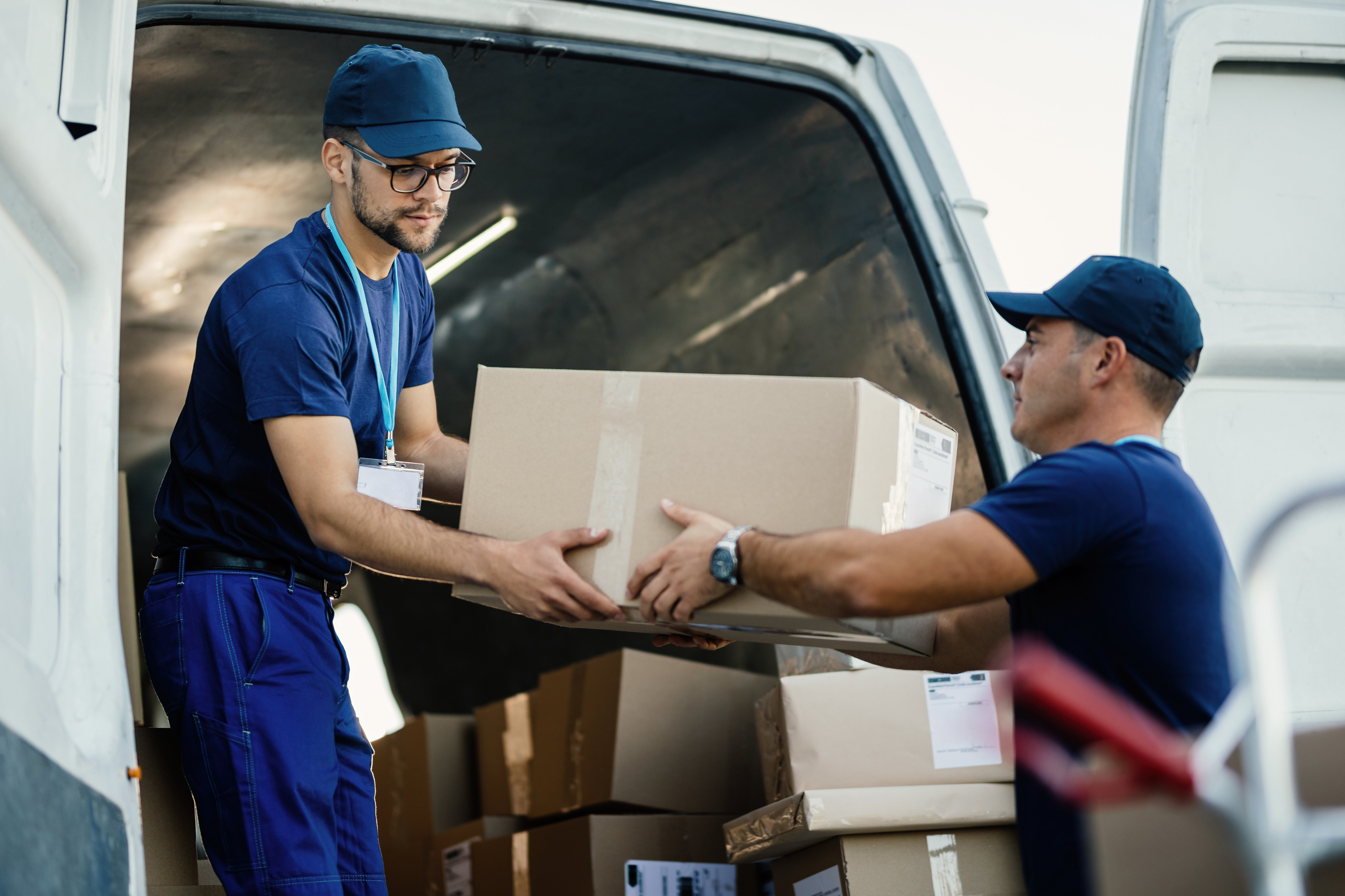 delivery-men-loading-carboard-boxes-van-while-getting-ready-shipment
