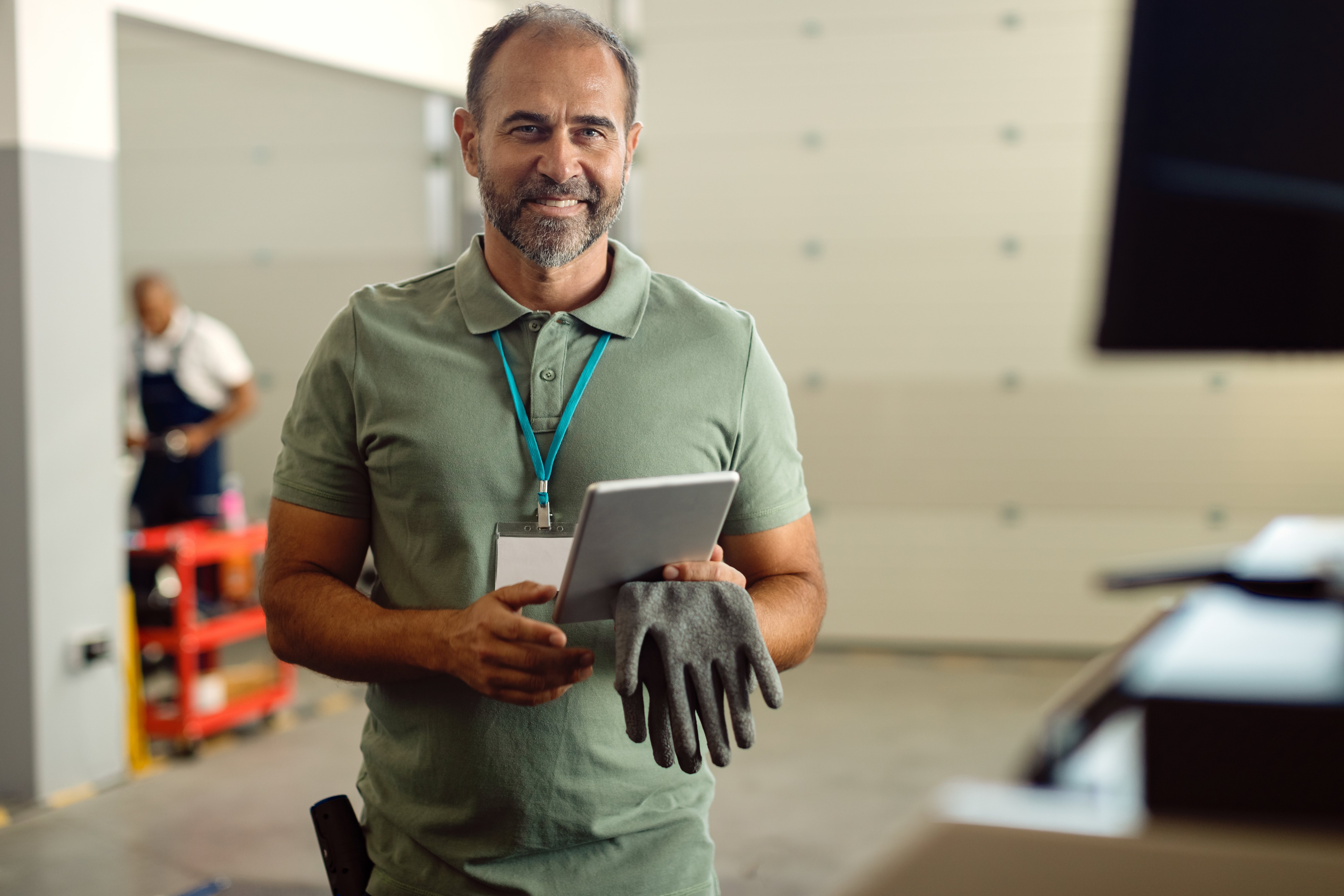happy-foreman-auto-mechanic-workshop-using-touchpad-looking-camera