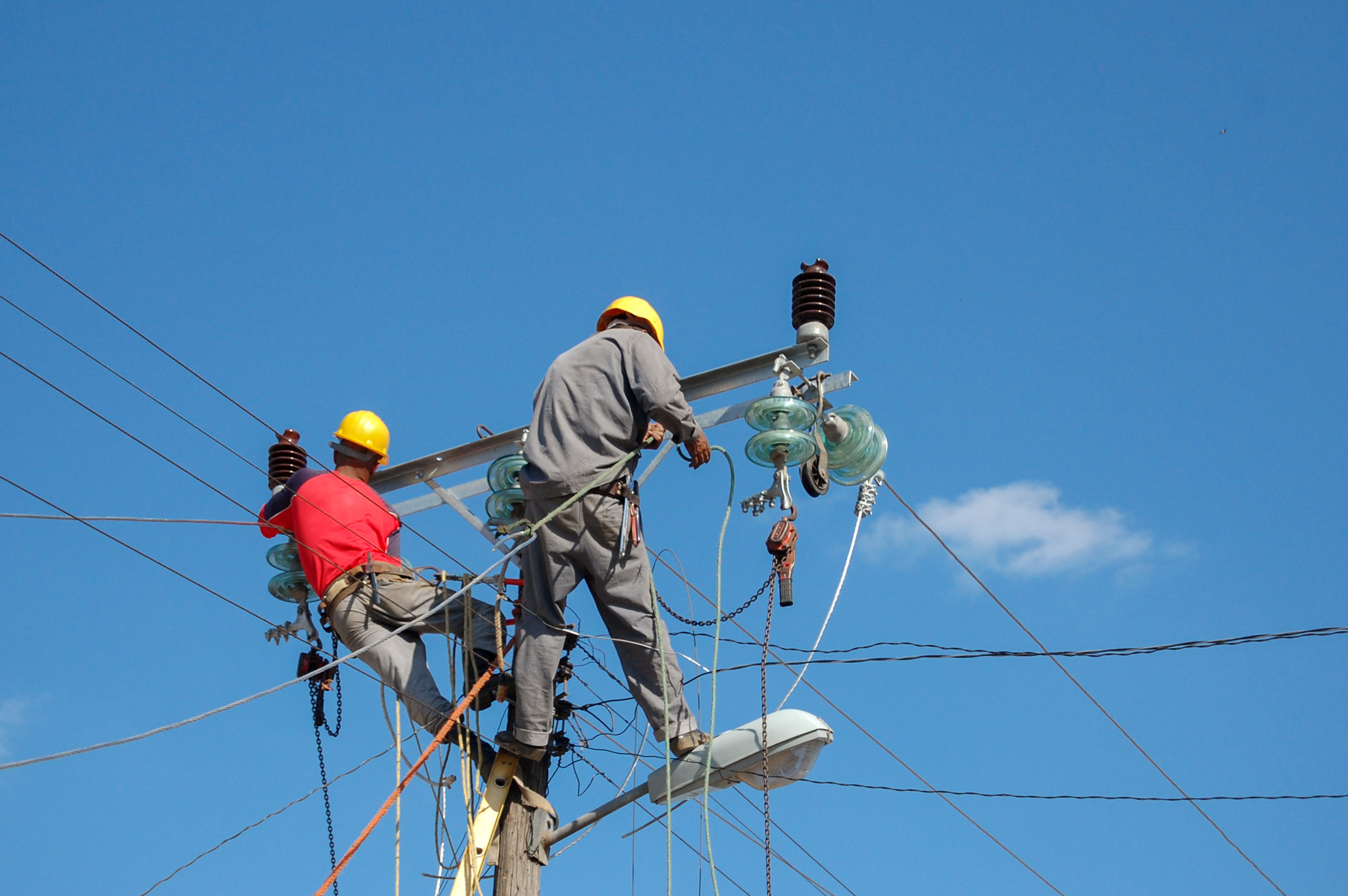 low-angle-shot-electric-linemen-working-pole (1)