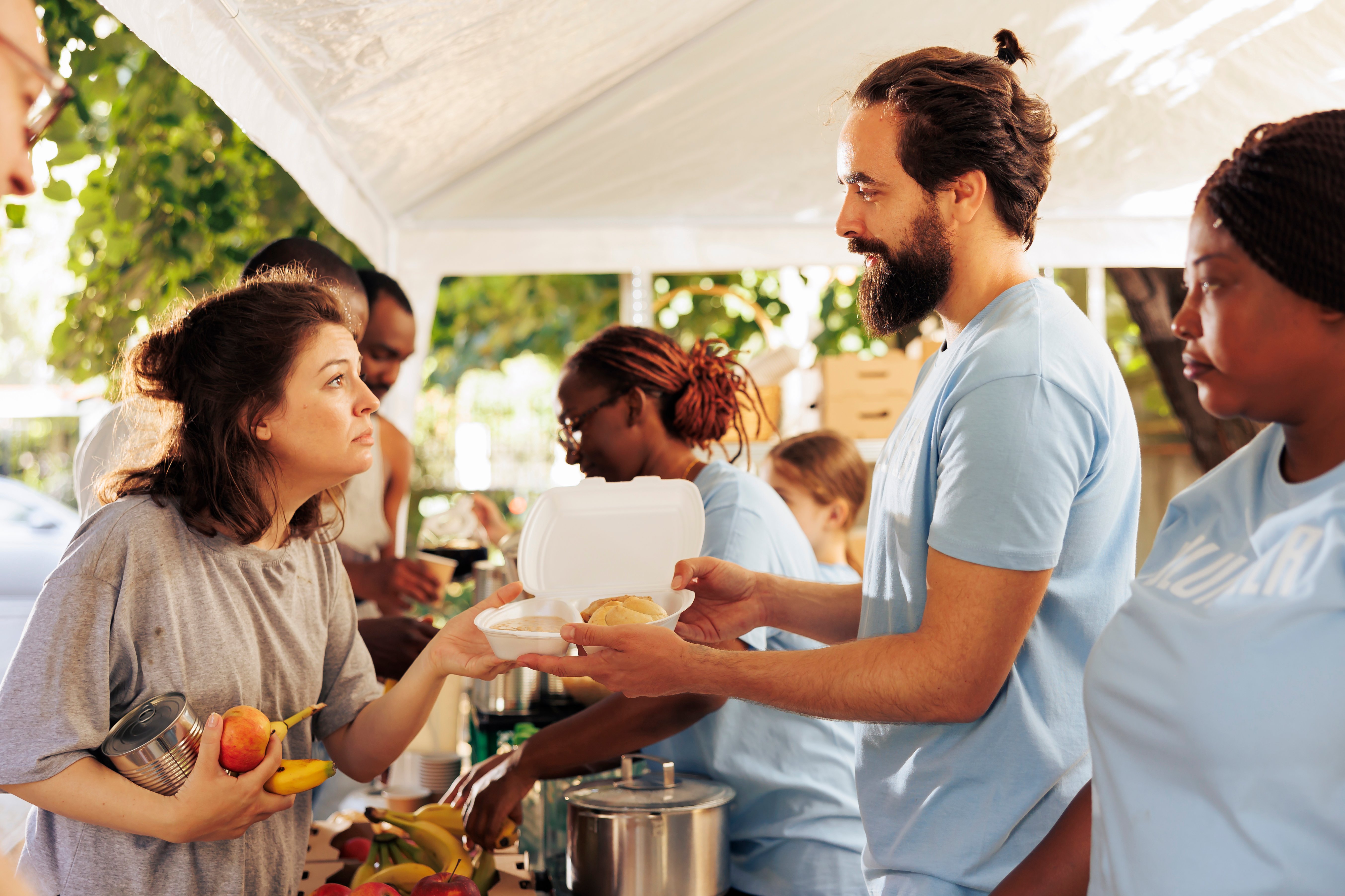 multiethnic-humanitarian-aid-team-provide-essential-support-needy-distribute-food-offer-assistance-through-local-non-profit-initiative-young-volunteers-share-warm-meals-homeless