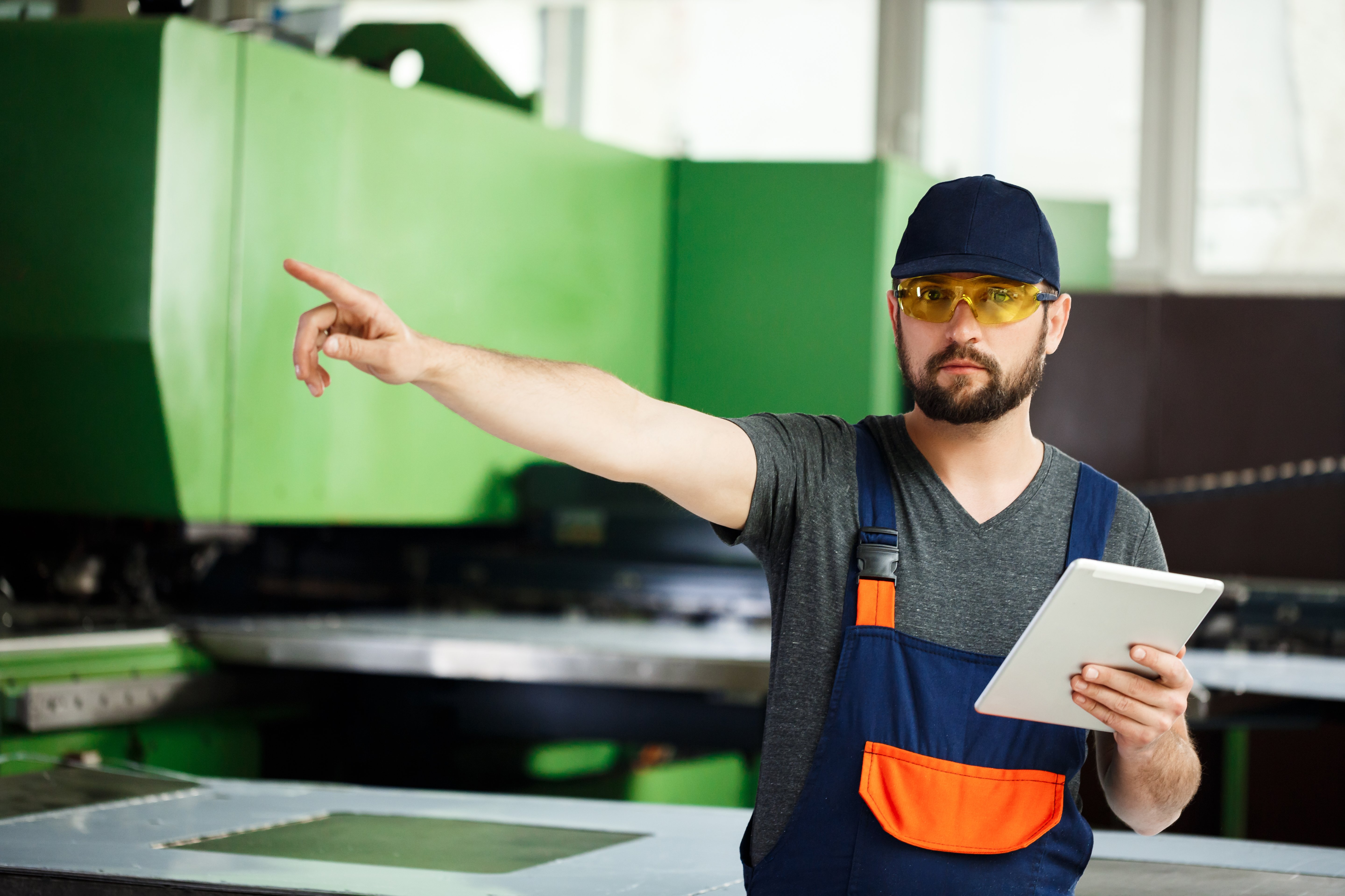 portrait-worker-pointing-finger-side-steel-factory-background