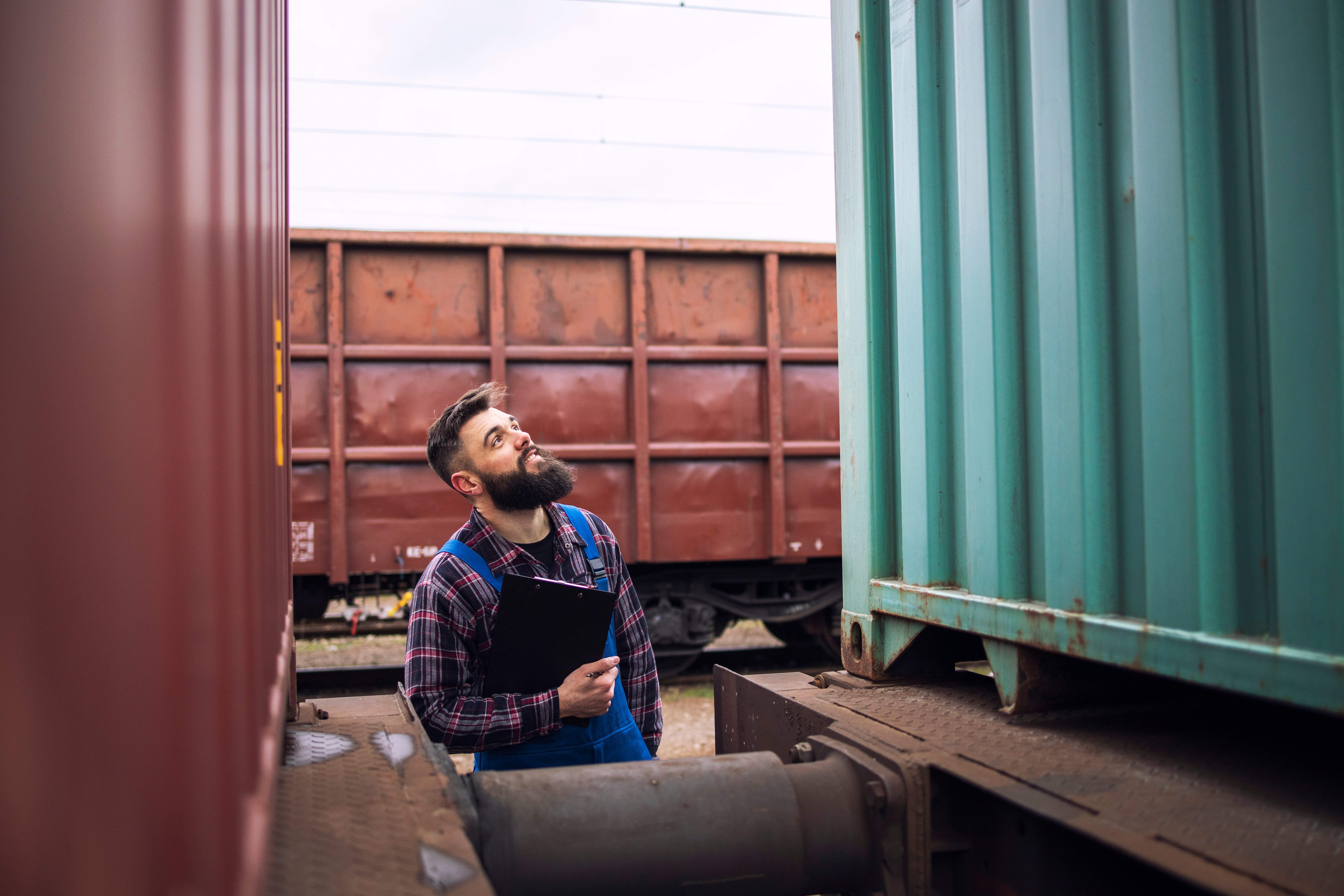 railroad-worker-supervisor-inspecting-shipping-cargo-container-freight-train-station