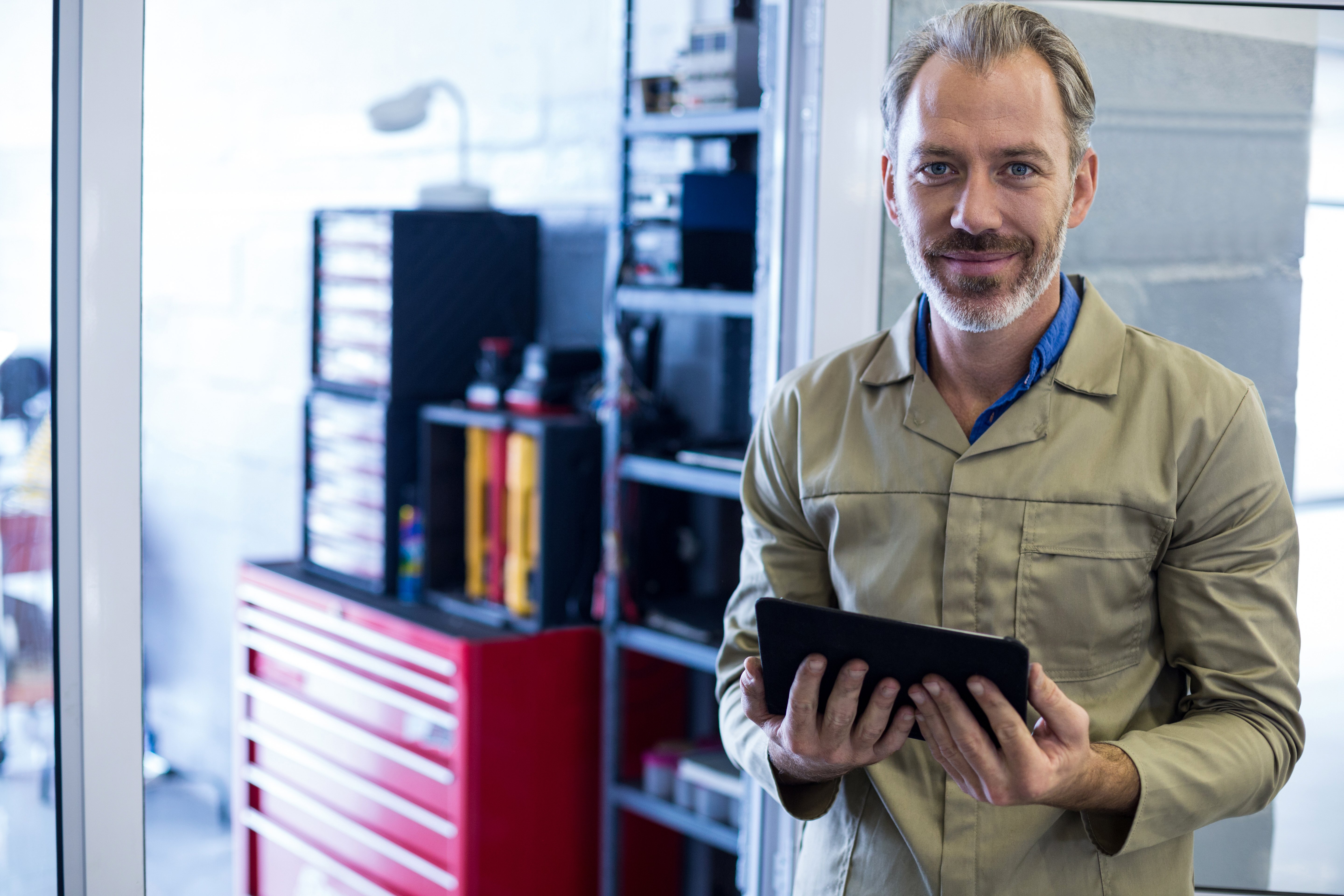 smiling-mechanic-holding-digital-tablet