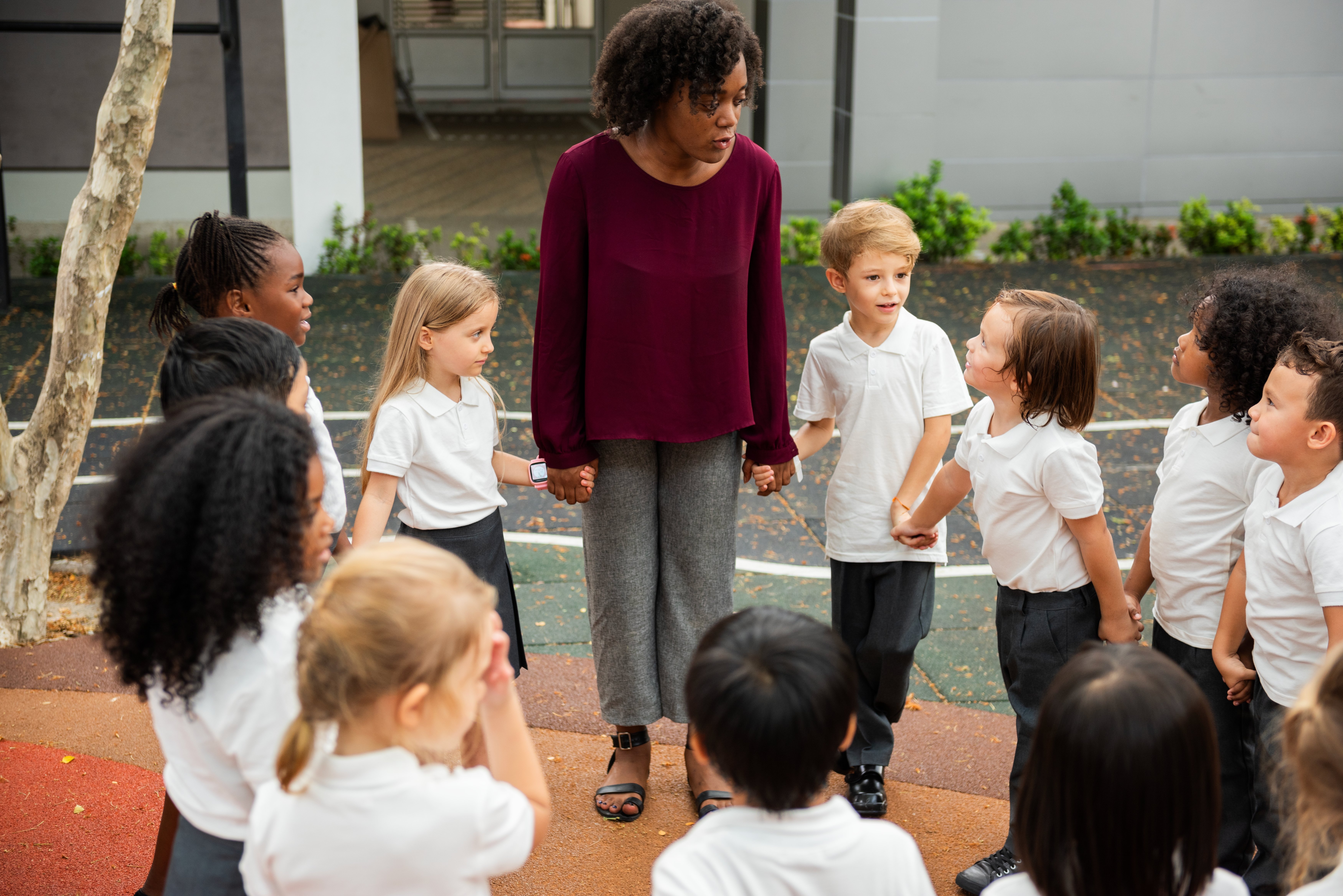 teacher-with-diverse-group-children-outdoors-kids-white-uniforms-engaged-teacher-attentive