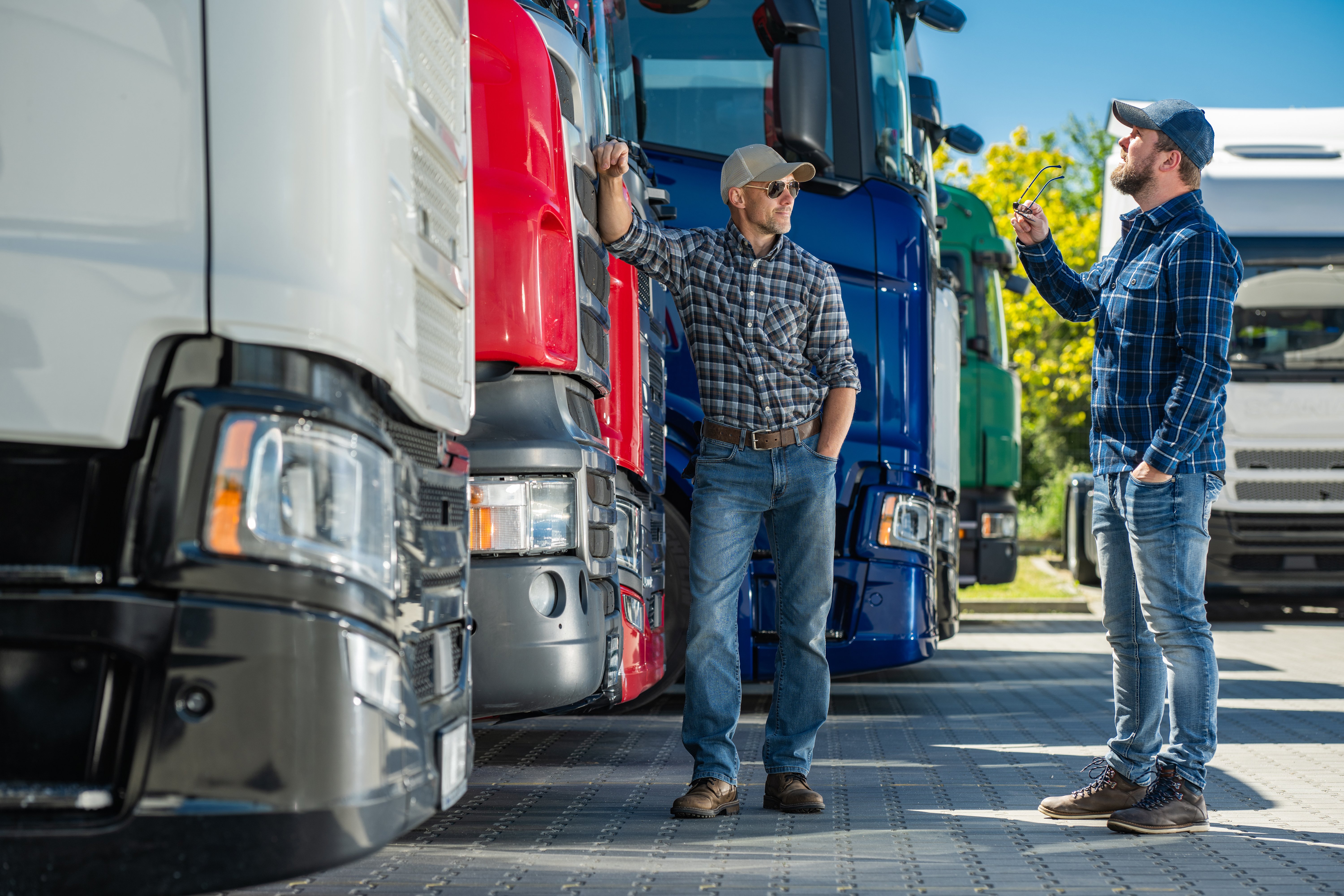 two-men-are-standing-several-semi-trucks-lined-up-row-they-appear-be-inspecting