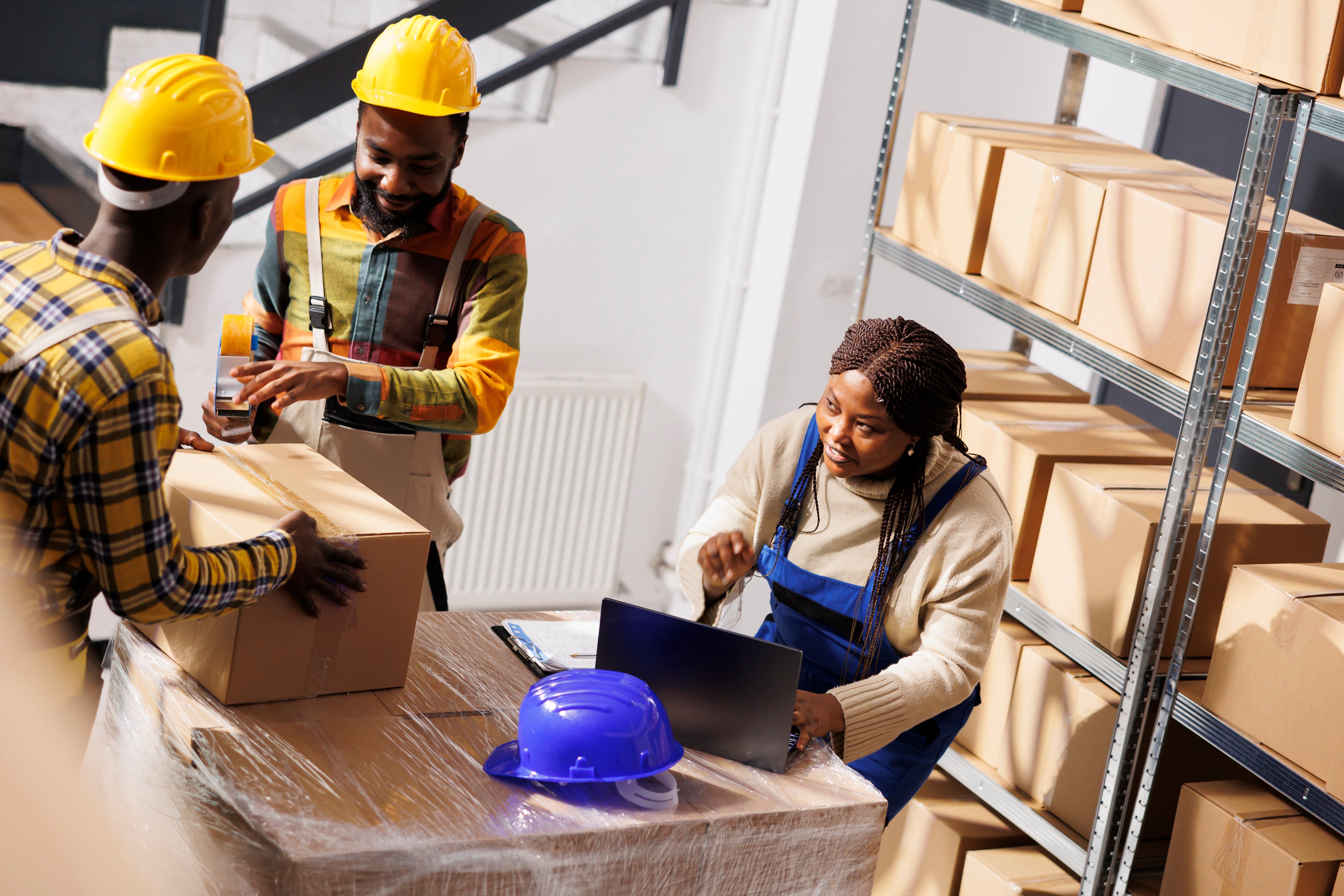 warehouse-manager-checking-orders-list-coordinating-parcels-packing-process-african-american-woman-supervisor-with-laptop-controlling-freight-cardboard-boxes-sealing-dispatching