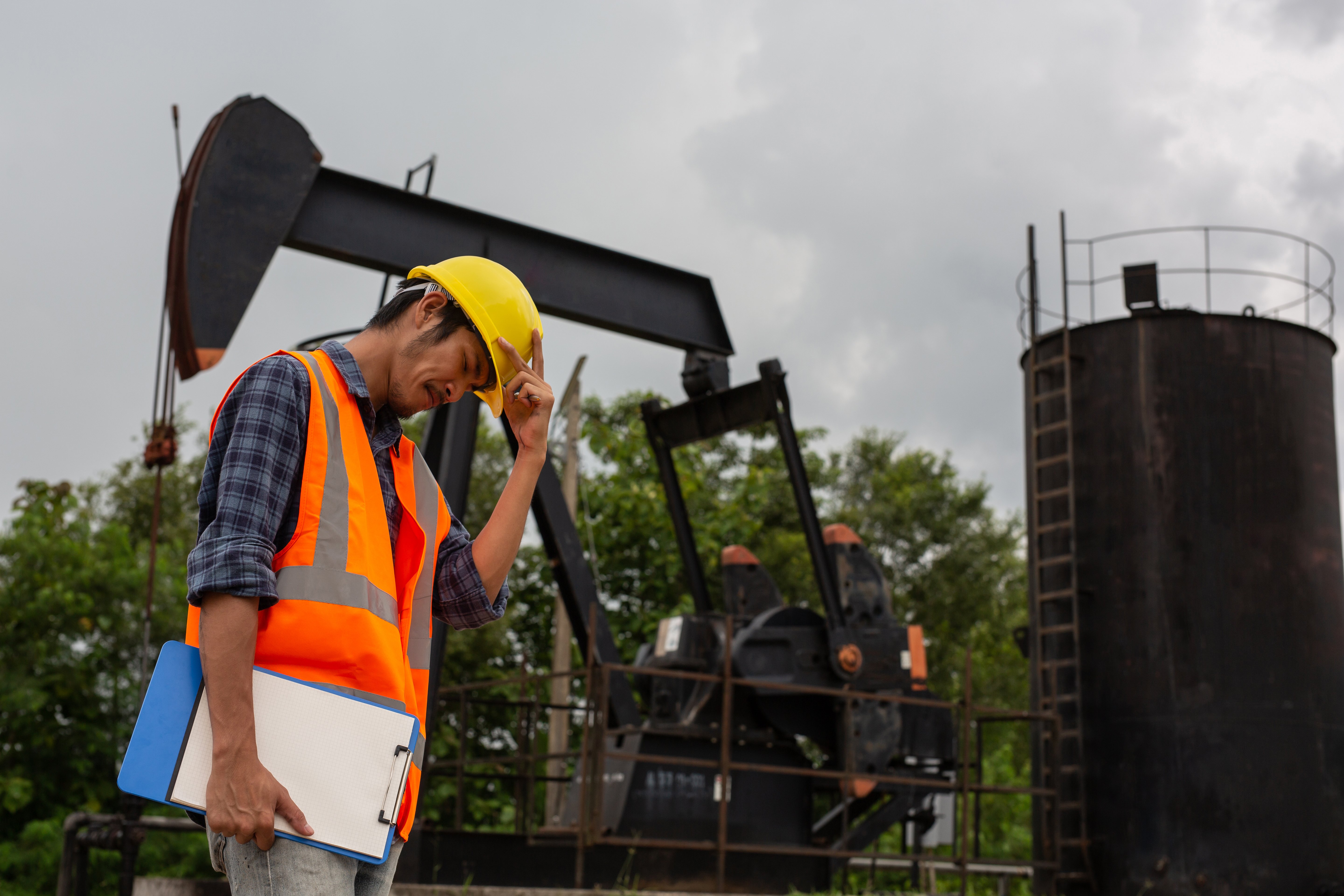 workers-standing-checking-beside-working-oil-pumps